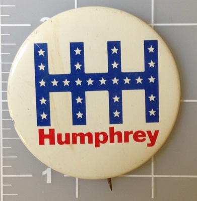 1.25 inch HHH Humphrey Muskie white campaign button with blue and red lettering. Union bug left side